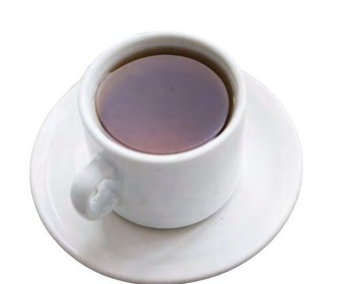 Tea with the Editor A top-down, high-angle view of a white ceramic teacup filled with dark amber tea or black coffee, resting on a matching round white saucer isolated on a plain background.