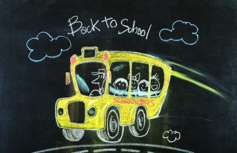 Tea with the Editor Colorful chalk drawing on a blackboard of a yellow school bus with smiling children and a driver, with "Back to School" written above.