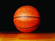 Tallahassee opens registration for fall sports Close-up of an orange basketball resting on a wooden floor against a black background.
