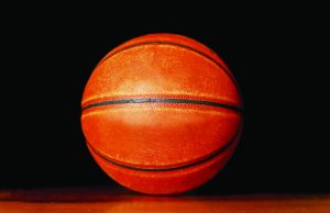 Tallahassee opens registration for fall sports Close-up of an orange basketball resting on a wooden floor against a black background.