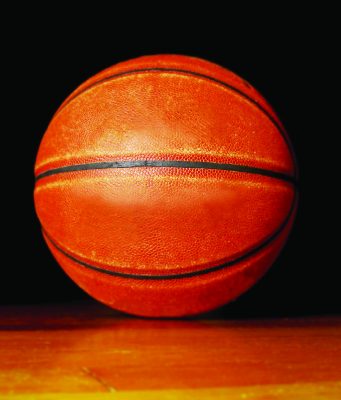 Tallahassee opens registration for fall sports Close-up of an orange basketball resting on a wooden floor against a black background.