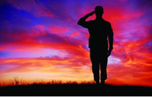 Interesting facts about Veterans Day Soldier saluting at sunset.