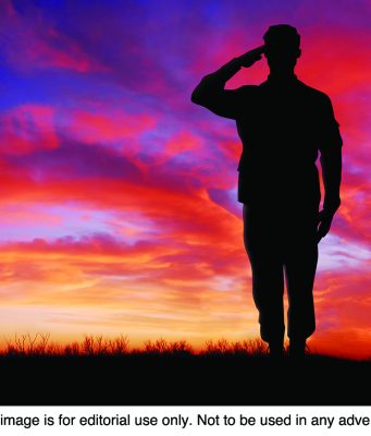 Interesting facts about Veterans Day Soldier saluting at sunset.