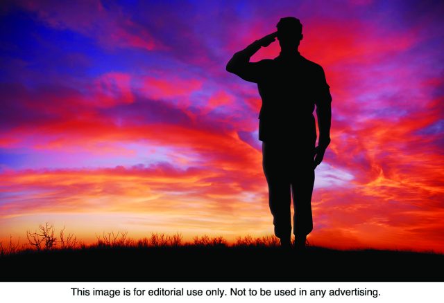 Veterans Day Soldier saluting at sunset.