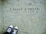 A timeline of notable events in the life of Martin Luther King, Jr. A photograph of engraved stone reading “I HAVE A DREAM – Martin Luther King Jr.”, referencing the March on Washington for Jobs and Freedom on August 28, 1963. The image is framed from above, with a pair of black-and-white sneakers visible at the bottom edge, creating a reflective, symbolic perspective on the historic inscription.