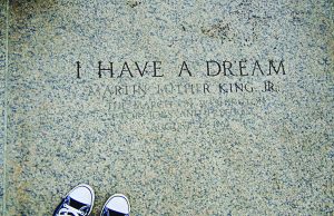 A timeline of notable events in the life of Martin Luther King, Jr. A photograph of engraved stone reading “I HAVE A DREAM – Martin Luther King Jr.”, referencing the March on Washington for Jobs and Freedom on August 28, 1963. The image is framed from above, with a pair of black-and-white sneakers visible at the bottom edge, creating a reflective, symbolic perspective on the historic inscription.