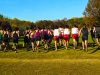 Tallahassee gearing up for major international sports weekend in January 2026 Group of high school cross-country runners seen from behind as they start a race across a grassy field with autumn trees in the background.